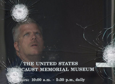 Un policía examina los impactos de bala en una de las puertas del Museo del Holocausto de Washington.