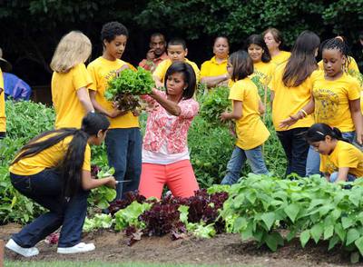 Michelle Obama, con los estudiantes, recogiendo lechugas en el huerto de la Casa Blanca.