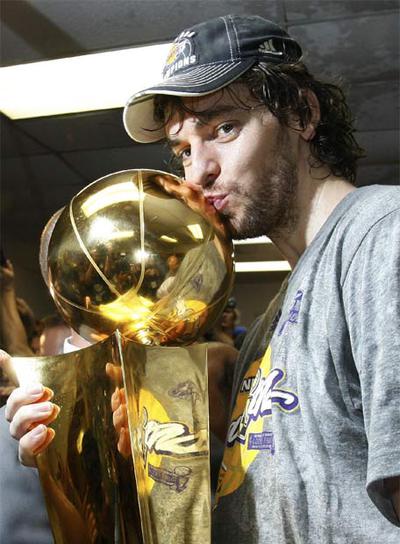 Pau Gasol besa el trofeo que acredita a los Lakers como campeones de la NBA.