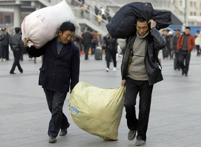 Dos trabajadores salen de la estación de tren de Pekín (China).