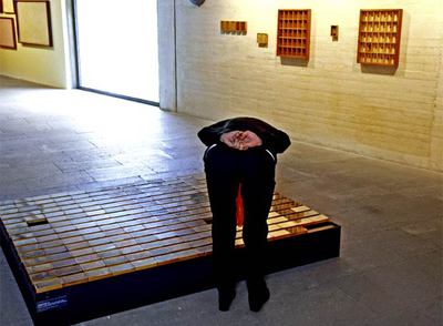 Una visitante observa las cajitas con objetos de la acción  Cadaverina 76,  de Barceló.