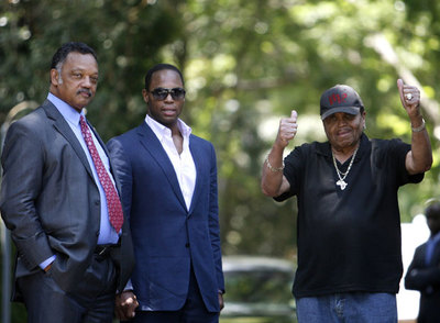 El padre de Michael Jackson, Joe (con gorra), con el reverendo Jesse Jackson (izquierda) y su hijo, en la casa falimiliar de Los Ángeles.