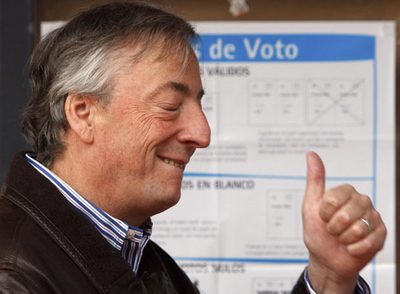 Néstor Kirchner, candidato al Congreso por Buenos Aires, hace un gesto de optimismo antes de votar.