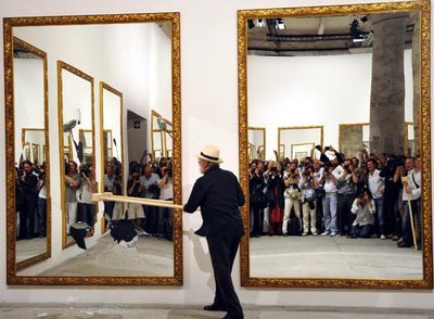 El artista Michelangelo Pistoletto rompe uno de los espejos de su instalación performance  en la Bienal de Venecia.