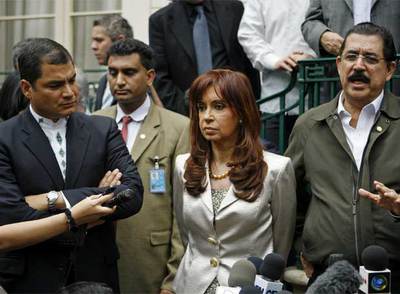 Los presidentes de Ecuador, Rafael Correa (izquierda), y Argentina, Cristina Fernández, junto a Manuel Zelaya, ayer rnen Washington. A la derecha, policías en el aeropuerto de Tegucigalpa.