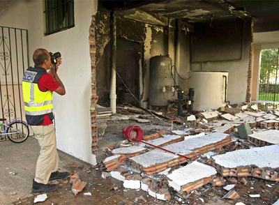Un policía fotografía los destrozos causados por la explosión.