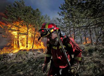 Un miembro de la Unidad Militar de Emergencias (UME) lucha contra el fuego en la localidad turolense de Cañizar del Olivar.