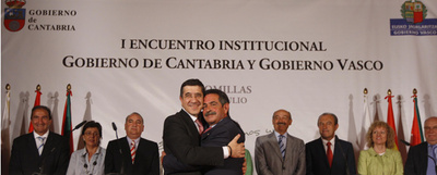 Patxi López y Miguel Ángel Revilla se abrazan tras la firma del protocolo de colaboración, en presencia de consejeros de ambos Ejecutivos.