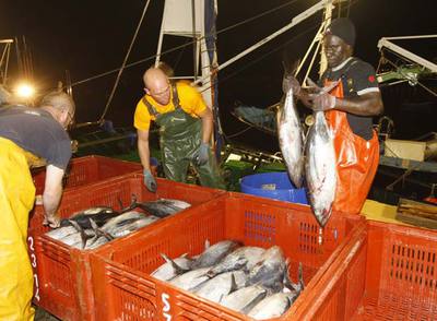 Un  arrantzale  senegalés junto a dos compañeros, el pasado jueves de madrugada,  en el muelle pesquero de Hondarribia.