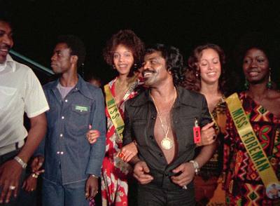 James Brown cogido del brazo de unas  misses,  en un fotograma del documental  Soul power .