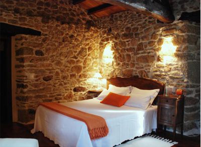 la habitación Lúa Chea (luna llena),  con  paredes de piedra vista.