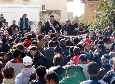 El alcalde de Lampedusa, Bernardino de Rubeis, se dirige a un grupo de  sin papeles  amotinados en la isla italiana el pasado 24 de enero.