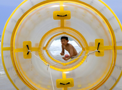 Un niño se baña en la orilla de la playa de Sanya, en China.