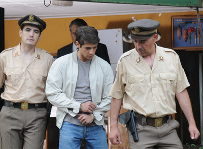 Rafael Escobedo (Félix Gómez) es escoltado por dos policías en una escena de  El crimen de los marqueses de Urquijo.  .