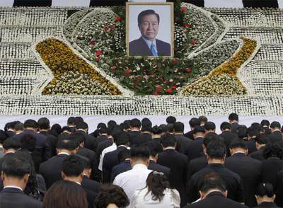 Asistentes a un acto en memoria de Kim Dae-jung, cuya foto preside la ceremonia, en Seúl.