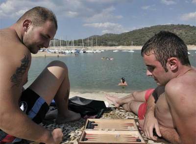 Unos bañistas juegan al  backgammon  en el pantano de San Juan.