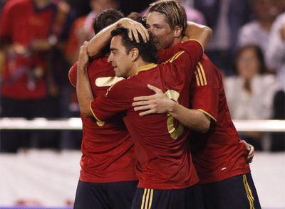 Villa, Xavi y Torres se abrazan tras uno de los goles.