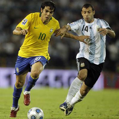 Kaká conduce el balón ante Mascherano.