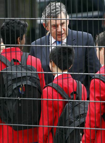 Brown charla con alumnos en una visita a una escuela en Londres.