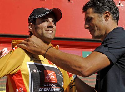 Miguel Indurain ajusta a Alejandro Valverde el  maillot  de líder.