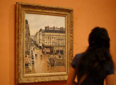 Una visitante del Museo Thyssen de Madrid contempla  Rue Saint Honoré aprês-midi. Effet de pluie , de Pissarro.