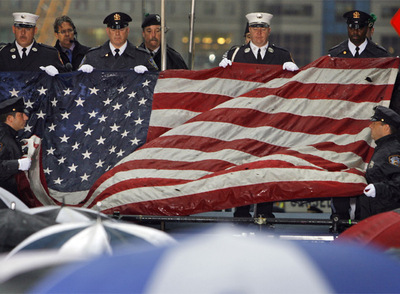 Un grupo de soldados y policías de Nueva York despliegan la bandera recuperada de las Torres Gemelas en el octavo aniversario del atentado.