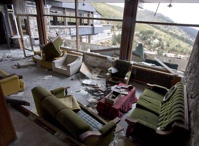 Arriba, estado deteriorado del Club Alpino Guadarrama, en el puerto de Navacerrada. Abajo, vista  del albergue juvenil Álvaro Iglesias, tomada desde el interior del edificio del club alpino.