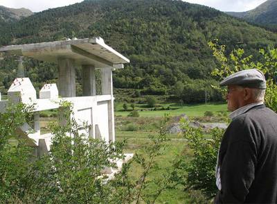 Un hombre observa el telesilla en Espui, parado a medio construir por causa de la crisis.
