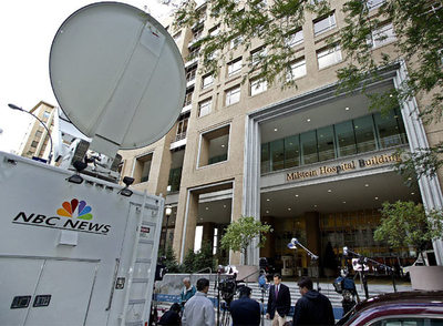 Equipos móviles de la NBC desplazados a la puerta de un centro hospitalario en el que se atendía al expresidente norteamericano Clinton.