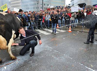 Un ganadero rocía con leche a un policía durante las protestas a las puertas de la Comisión Europea.