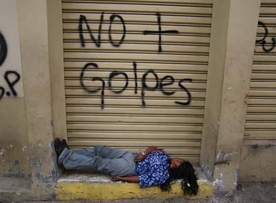 Una mujer duerme en un portal de Tegucigalpa.