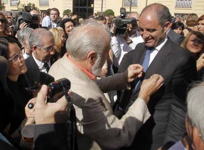 Un invitado impone una insignia a Francisco Camps.