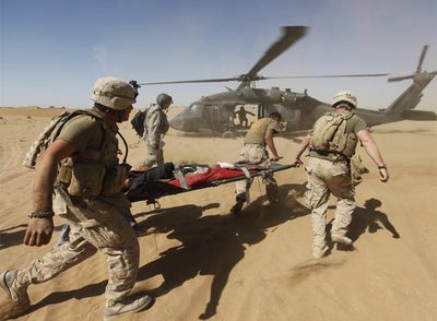  Marines  estadounidenses evacuan a un joven afgano herido durante una operación en Helmand.