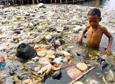 Un niño indonesio juega en una balsa de agua llena de basura en Muara Baru, al norte de Yakarta.