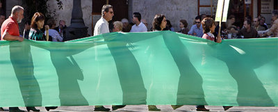 Los miembros de la Plataforma en Defensa de la Salud Mental desplegaron un enorme lazo verde, ayer, en la plaza de la Virgen, en Valencia.