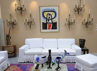 Arriba, un salón de Saint Laurent en el que está colgado el cuadro  Equinoxe  de Miró.