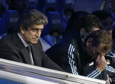 Pellegrini, a la izquierda, sigue el partido desde el banquillo.