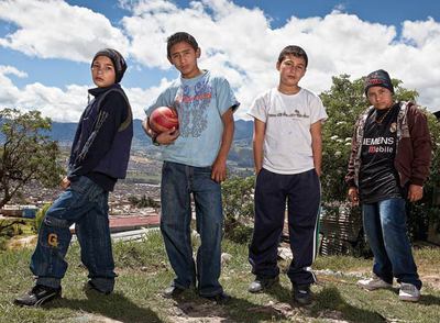 Los hermanos Alonso y su amigo Quevedorn Al fondo, Ciudad Bolívar. Miles de infraviviendas se levantan colina arriba, pobladas por un millón de desplazados huidos del conflicto armado en busca de salida. Pero lo que abunda es la falta de trabajo y de infraestructuras, la violencia, la desesperanza y las ONG activas en la zona. Es territorio ideal para las canteras de paramilitares y guerrillas varias. En la foto, Sebastián, Camilo Quevedo, Santiago y Sergio.