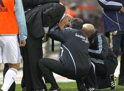 Los médicos del Real Madrid atienden a Pellegrini tras ser agredido.