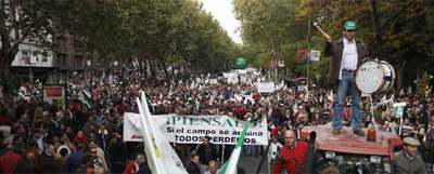 Manifestantes en el paseo del Prado, en Madrid, marchan con tractores hasta la estación de ferrocarriles de Atocha con una pancarta que dice 