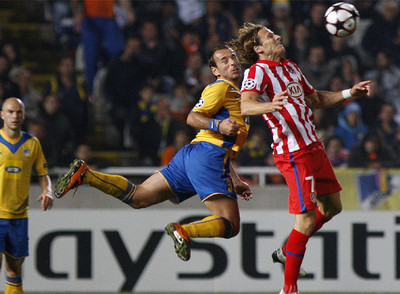 Michail y Forlán luchan por el balón.