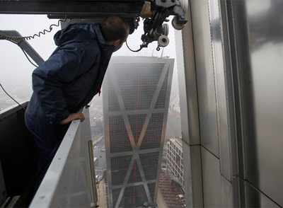 Román Cuadrado, subido a la  góndola  desde la que limpia los cristales de los edificios Puerta de Europa.