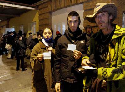 Minea, Manuel y Agustín (de izquierda a derecha) muestran sus cartillas para cenar en el comedor de Casa de Campo.
