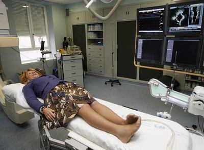 Esperanza Aguirre posa tumbada en la camilla de la sala de Hemodinámica, inaugurada ayer en el hospital Clínico.