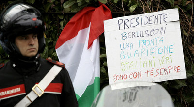 Un cartel en el hospital donde está ingresado Berlusconi le desea una pronta recuperación y dice que los verdaderos italianos están con él.rnUna réplica del Duomo sobre una imagen de Berlusconi.