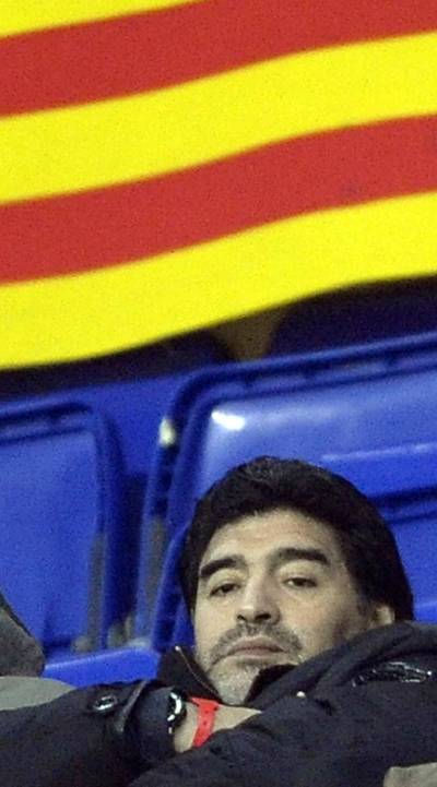 Diego Maradona, sancionado por la FIFA, en la tribuna bajo una  senyera. 