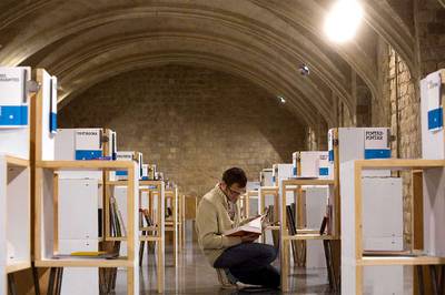 Una persona hojeando uno de los libros expuestos en la sede del FAD de Barcelona.