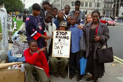 UN PASADO 'PACIFISTA'. Abdulmutallab (izquierda, en primer término), visitó en 2001 con sus compañeros del internado de Togo al activista Brian Haw (centro, sentado), conocido por sus sentadas pacifistas frente al Parlamento británico, en Londres. La fotografía fue difundida anteayer por su autor, el profesor MIke Rimmer.