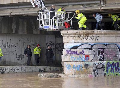 Los bomberos de Málaga, en el momento en el que rescataban ayer a los dos indigentes del puente de Tetuán tras la crecida del río Guadalmedina.rnUn vecino intenta salvar animales de su corral en Valderrubio.
