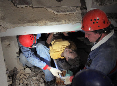 El equipo de rescate ruso saca a una chica de entre los escombros de su casa el sábado en Puerto Príncipe.